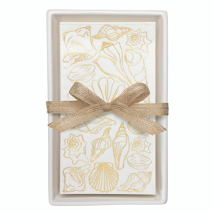 White ceramic guest napkin tray with gold shell-print napkins tied with burlap ribbon