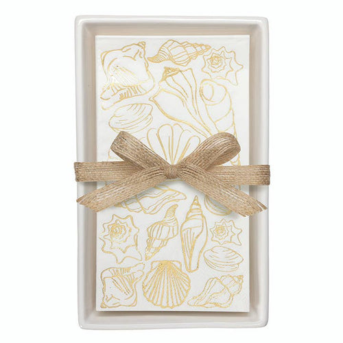 White ceramic guest napkin tray with gold shell-print napkins tied with burlap ribbon
